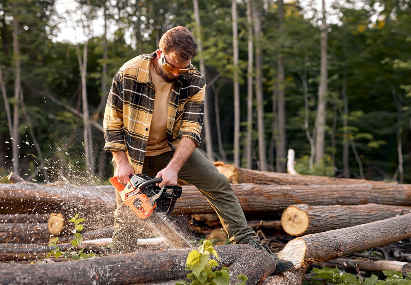 Man chain sawing lumber
